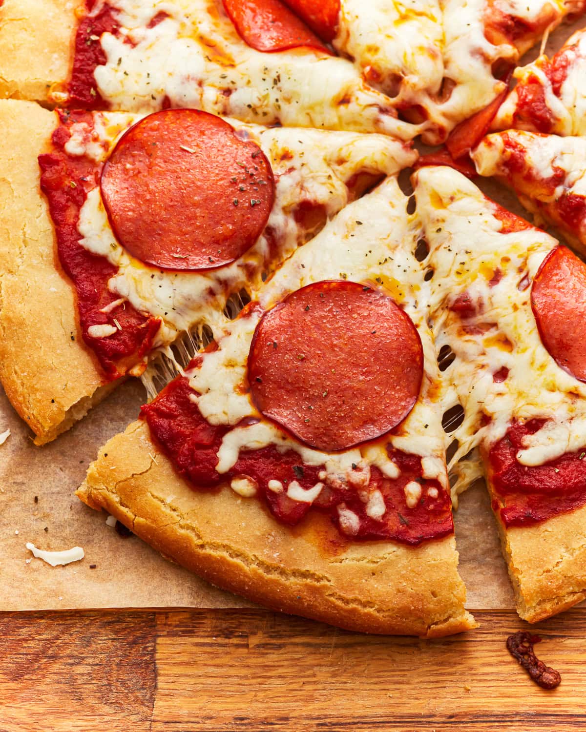 partial overhead view of a sliced gluten-free pepperoni pizza.