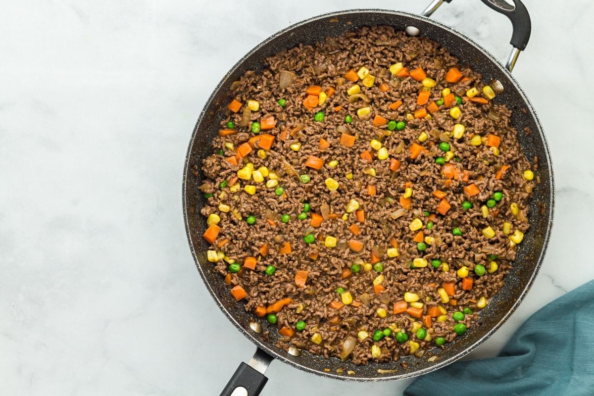 Vegetables added to the ground beef mixture.