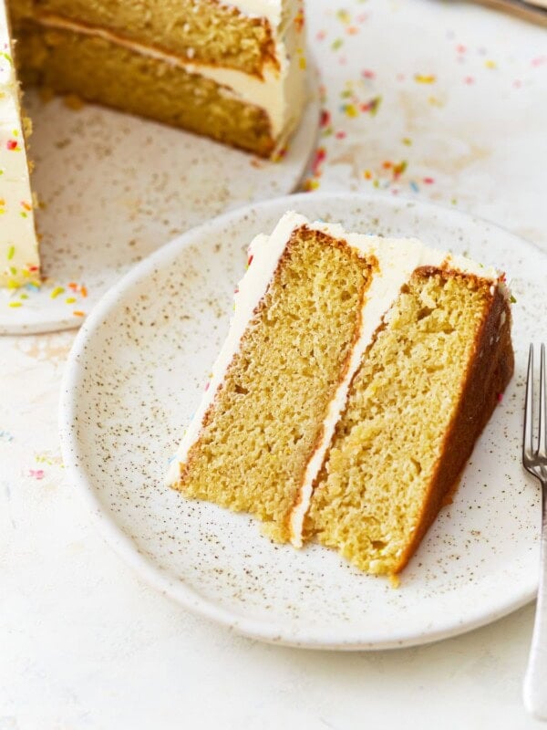 a slice of gluten free vanilla cake on a plate with a fork.