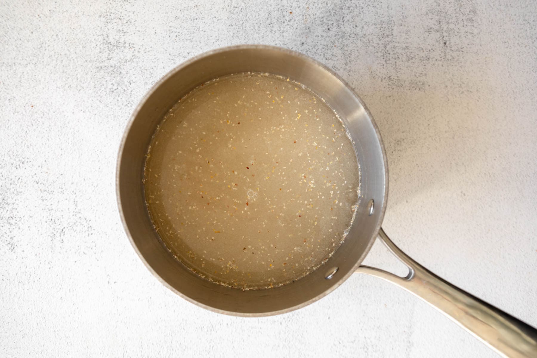 Water and uncooked grits in a saucepan.