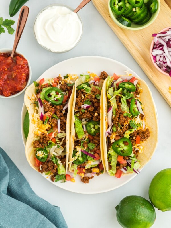 overhead view of 3 gluten-free tacos on a white plate.