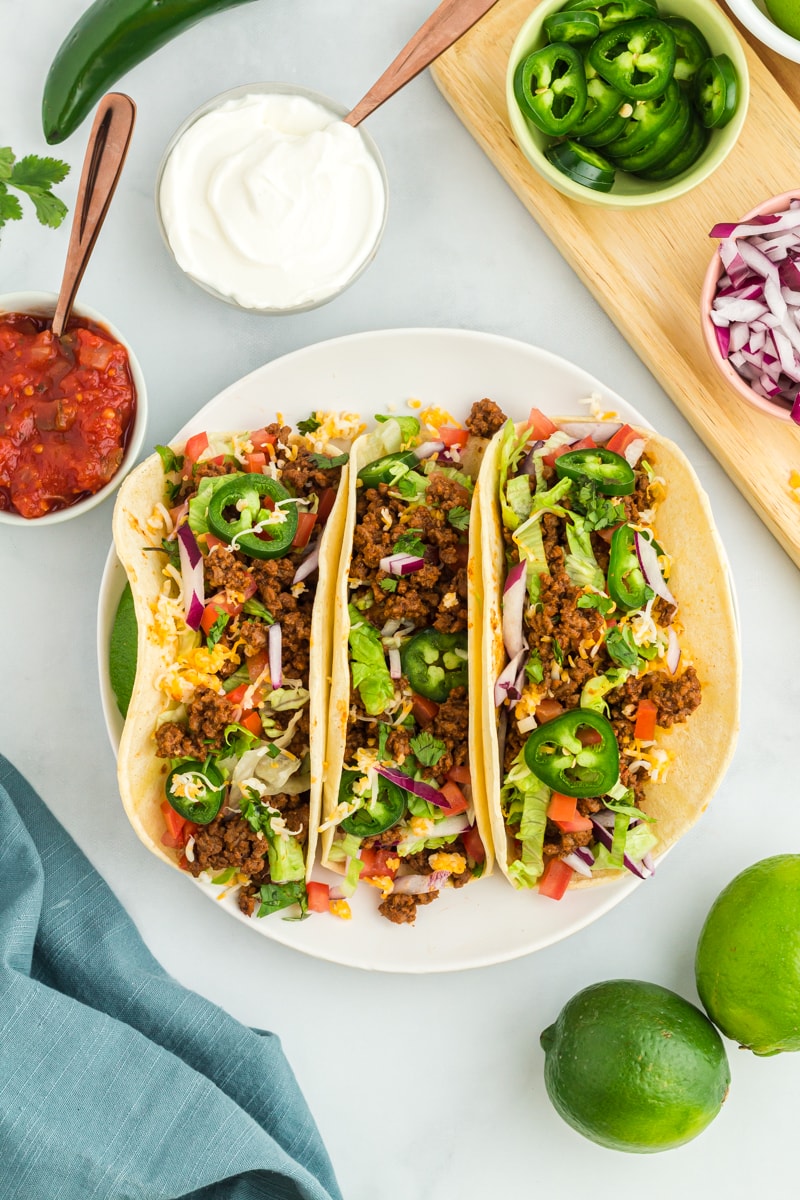 overhead view of 3 gluten-free tacos on a white plate.