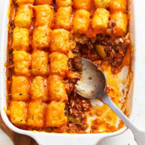 partially scooped out sloppy joe tater tot casserole with a spoon.