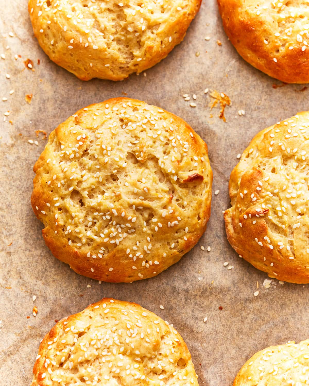 overhead view of gluten-free hamburger buns on parchment.