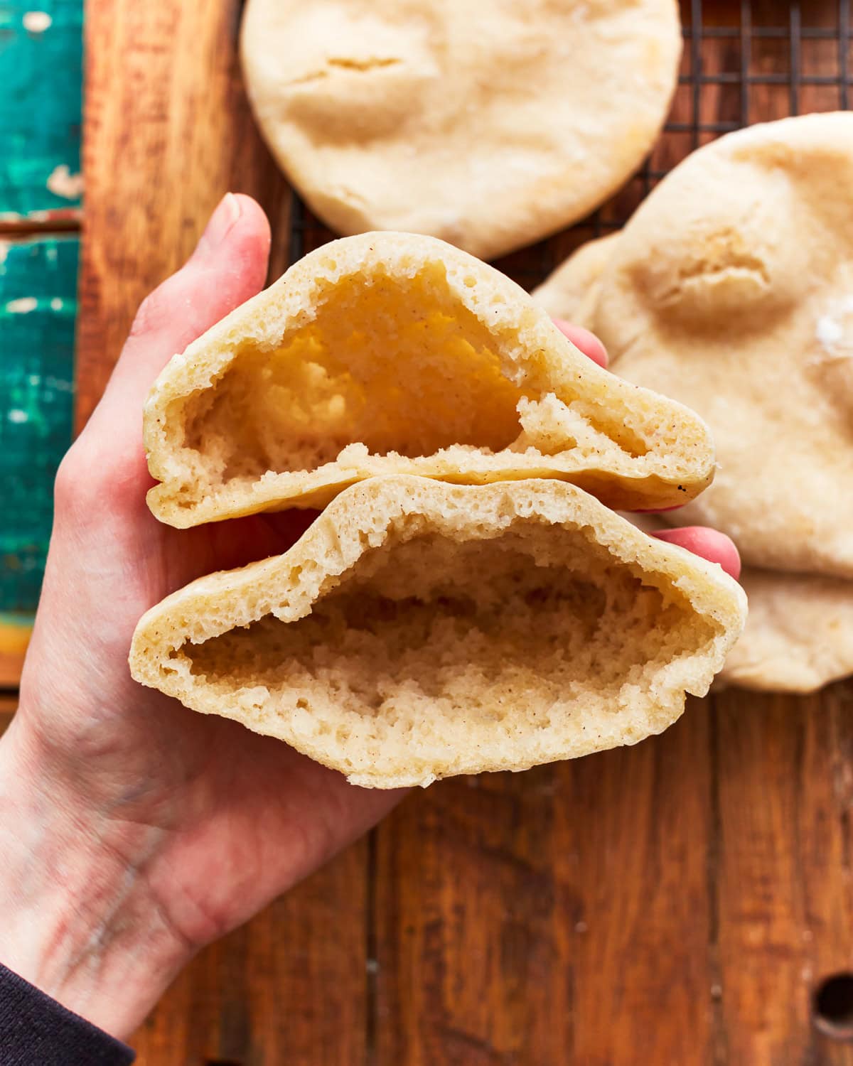 holding a halved gluten-free pita to show the pocket.