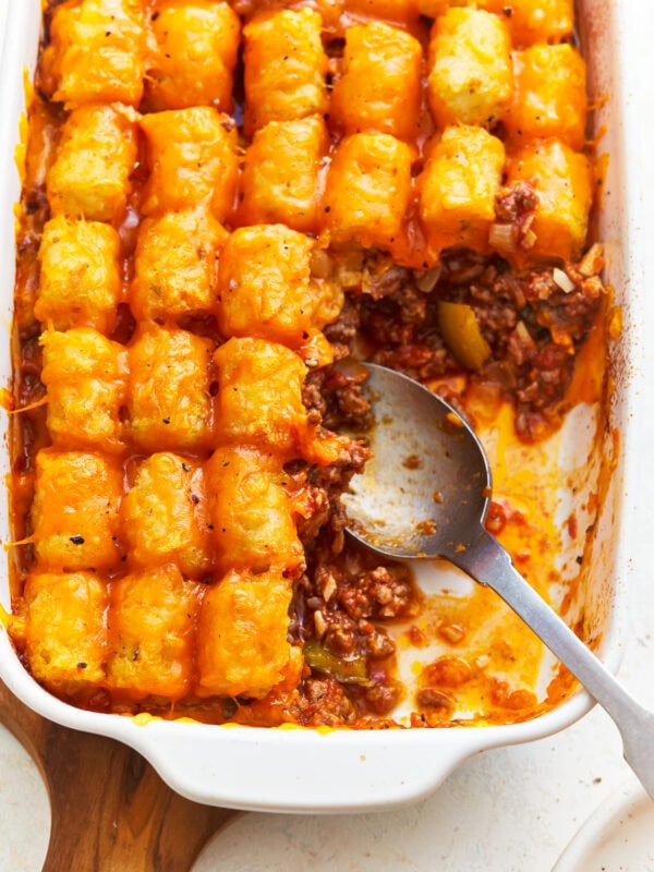 partially scooped out sloppy joe tater tot casserole with a spoon.