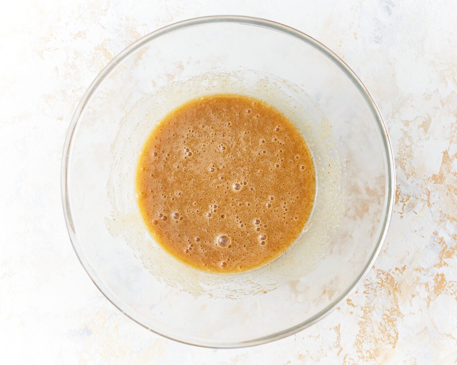 Wet ingredients for gluten-free zucchini in a glass mixing bowl.