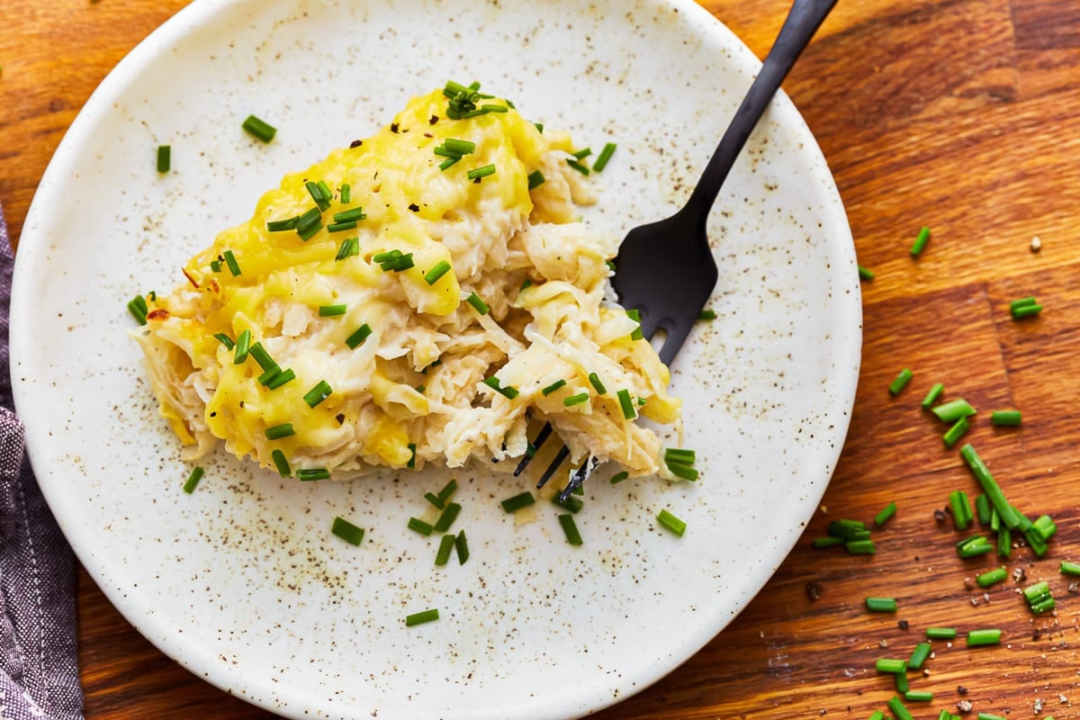 Overhead view of a plate of dairy-free cheesy potatoes with a fork.