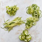 spiralized zucchini noodles, juliened zucchini noodles, and shaved zucchini noodles in piles
