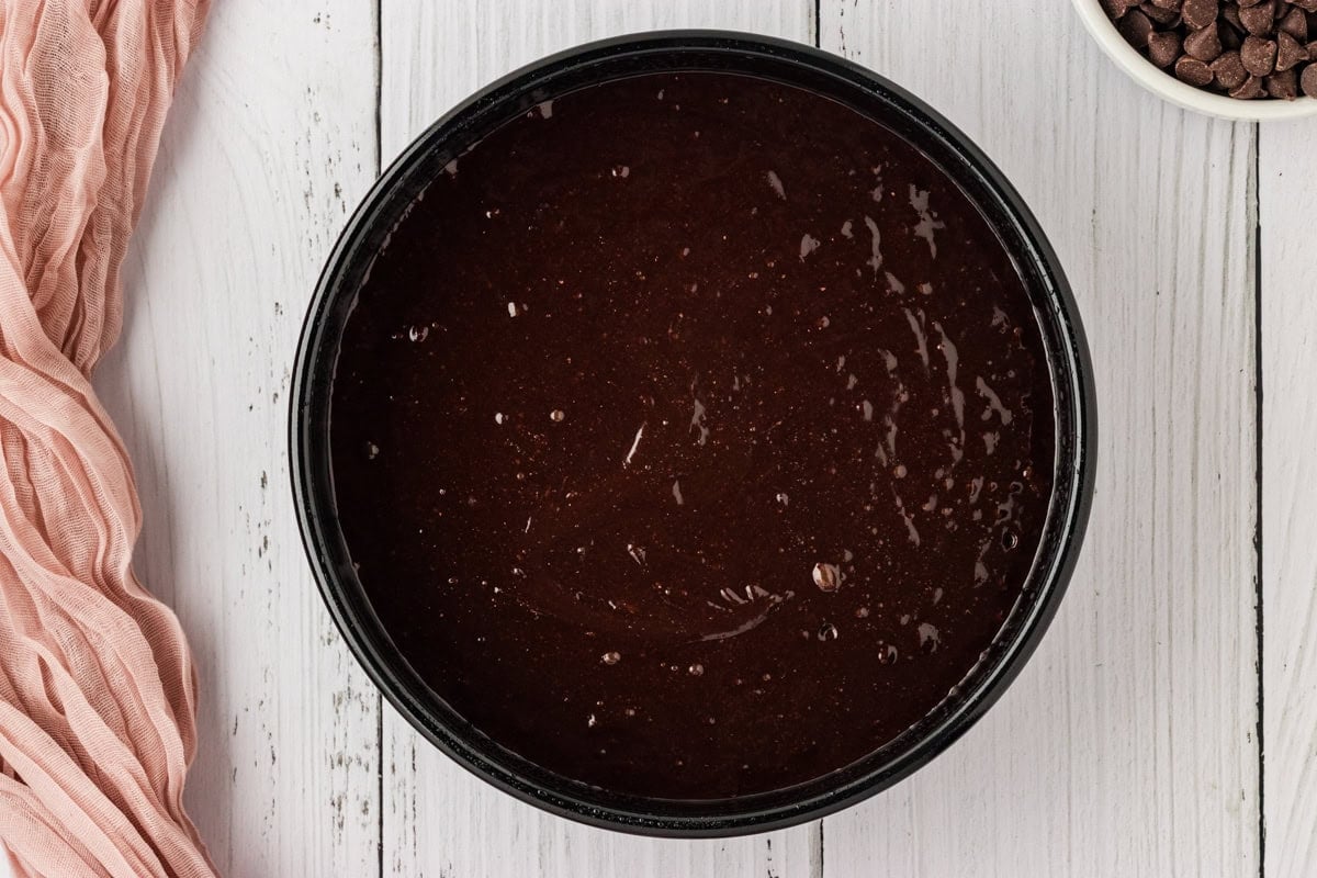 flourless chocolate cake batter in greased circular cake pan