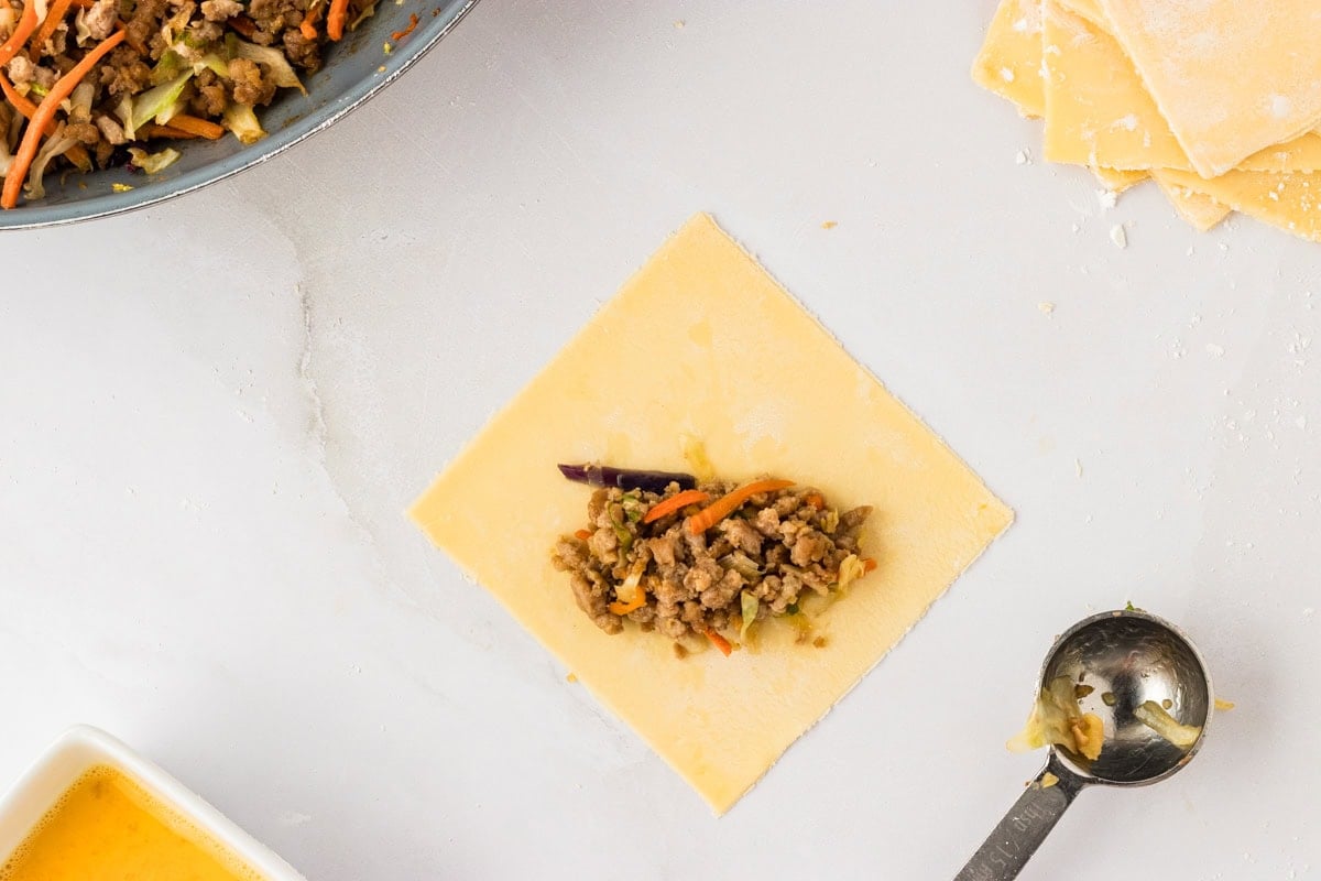 gluten-free egg roll dough square with filling in the center