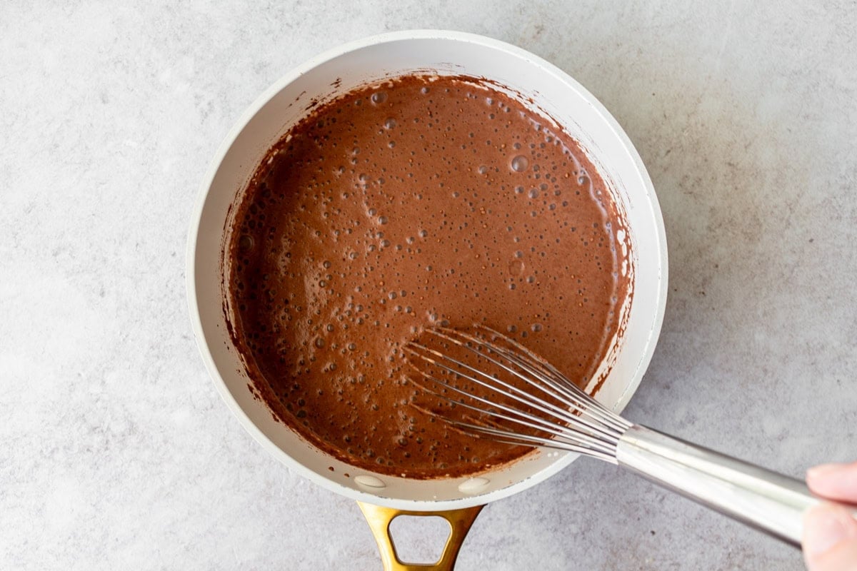 liquid chocolate in saucepan being whisked