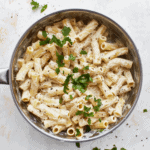 An overhead view of a pot with gluten-free Boursin cheese pasta with a parsley garnish
