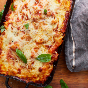zoomed in picture of gluten-free baked ziti in black baking dish