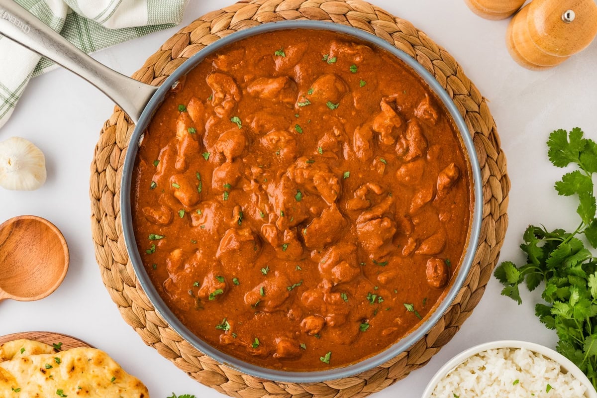 skillet with dairy-free butter chicken garnished with chopped cilantro