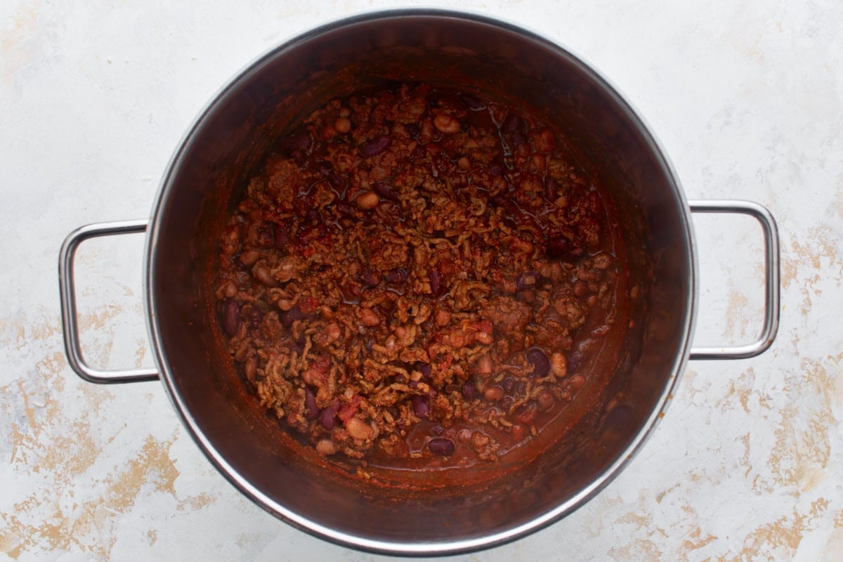 Gluten-free chili simmering in a pot with ground beef and beans
