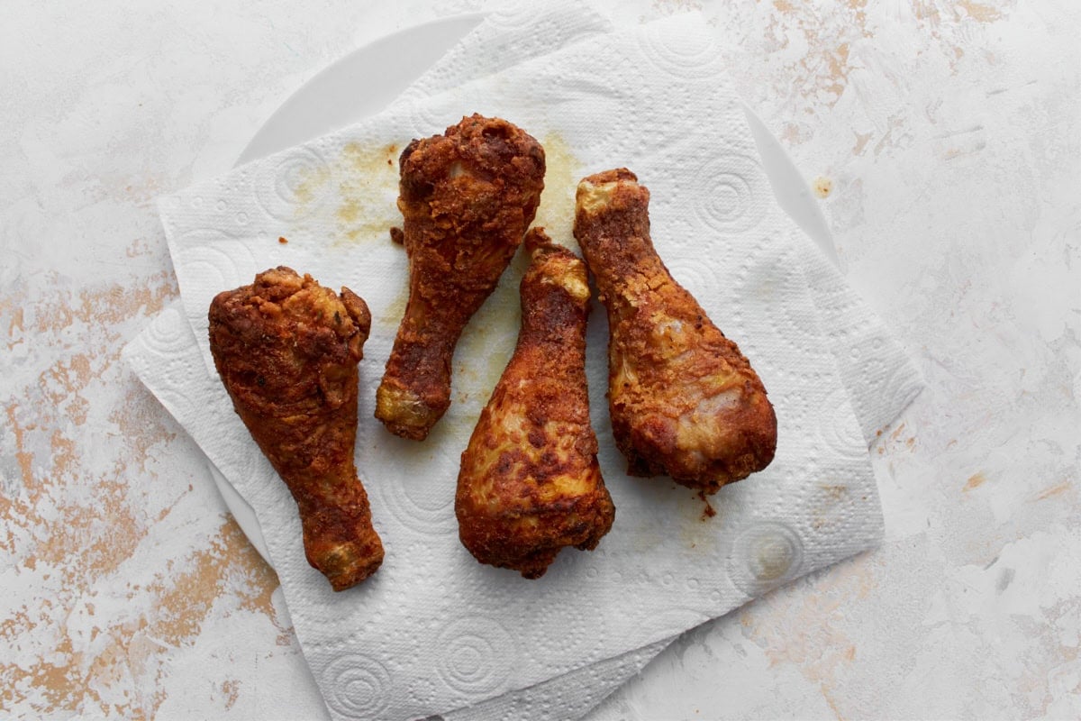 Four gluten-free fried chicken drumstick resting on a paper towel