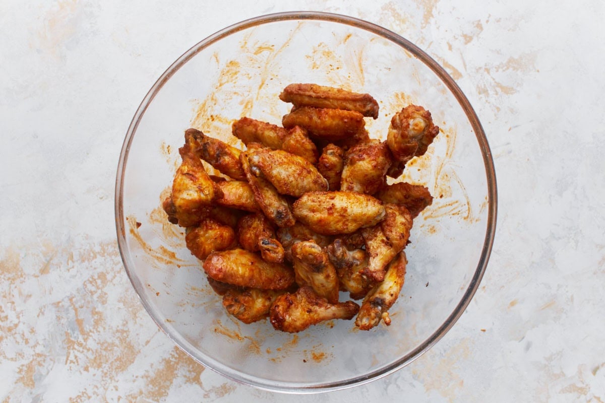 gluten-free buffalo sauce coated chicken wings in a glass bowl