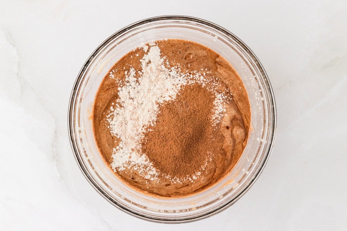 Cocoa powder and gluten-free flour being folded into chocolate lava cake batter