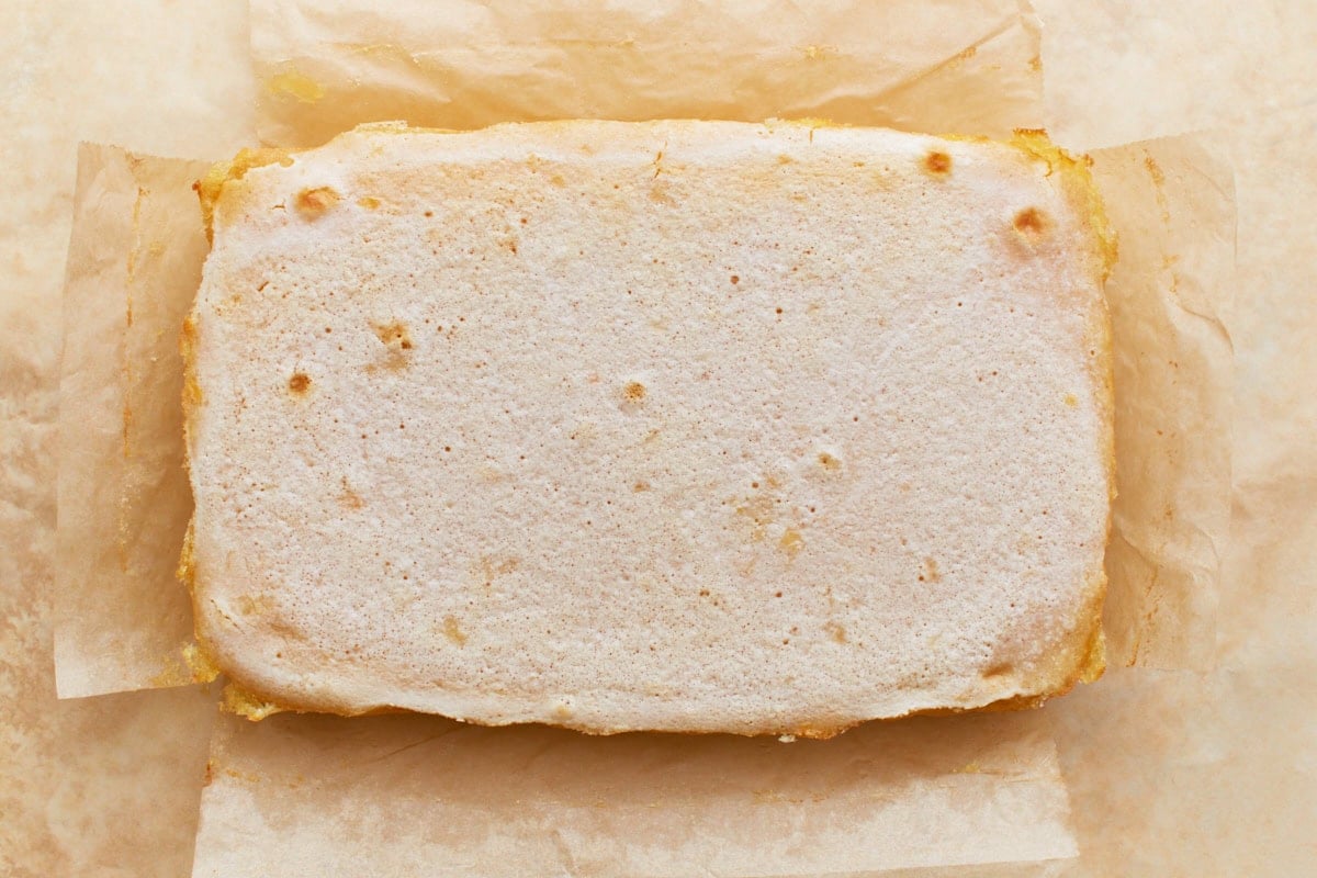 Baked and set gluten-free lemon bars, uncut, laying on parchment paper