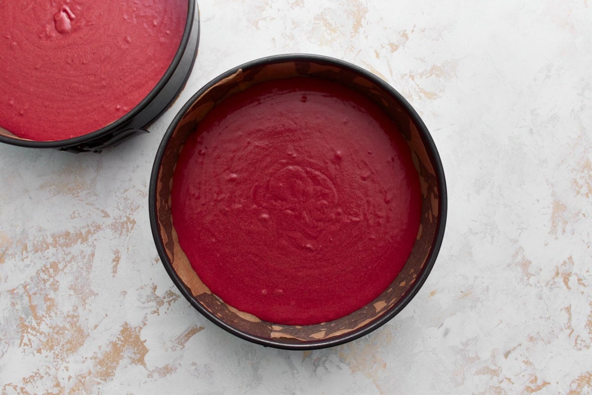 two cake pans with gluten-free red velvet cake batter in them