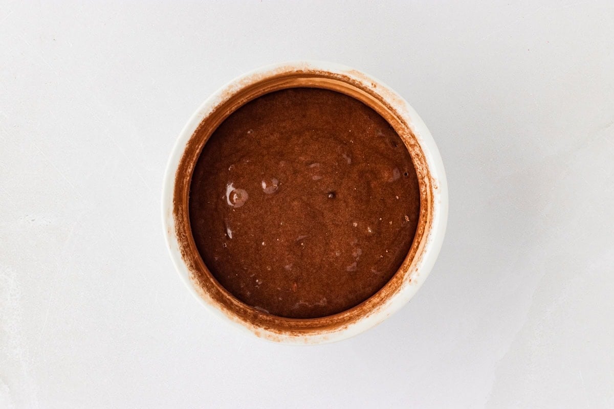 Dusted white ramekin with gluten-free chocolate lava cake batter 