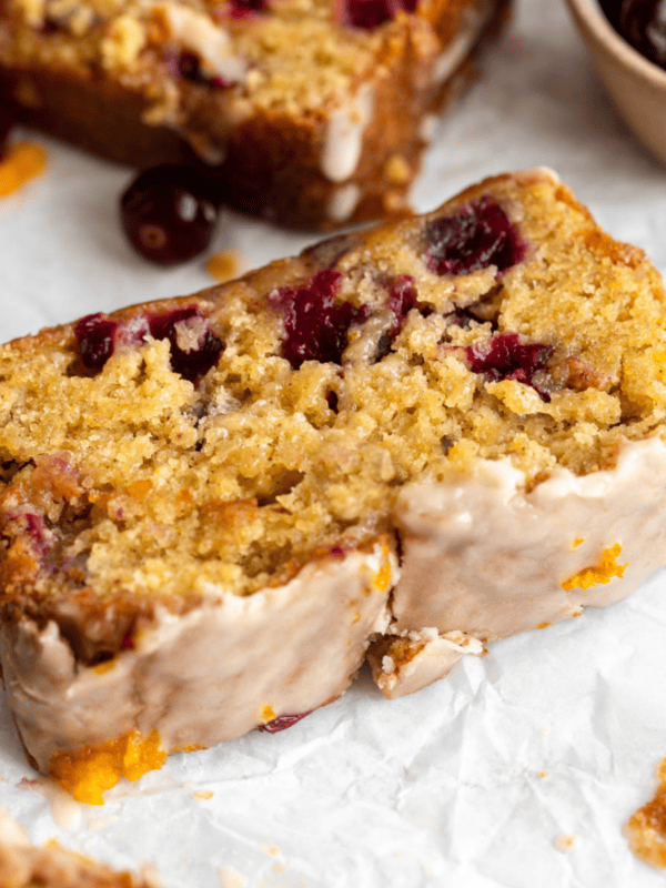 a close up of a slice of gluten-free cranberry bread with an orange glaze