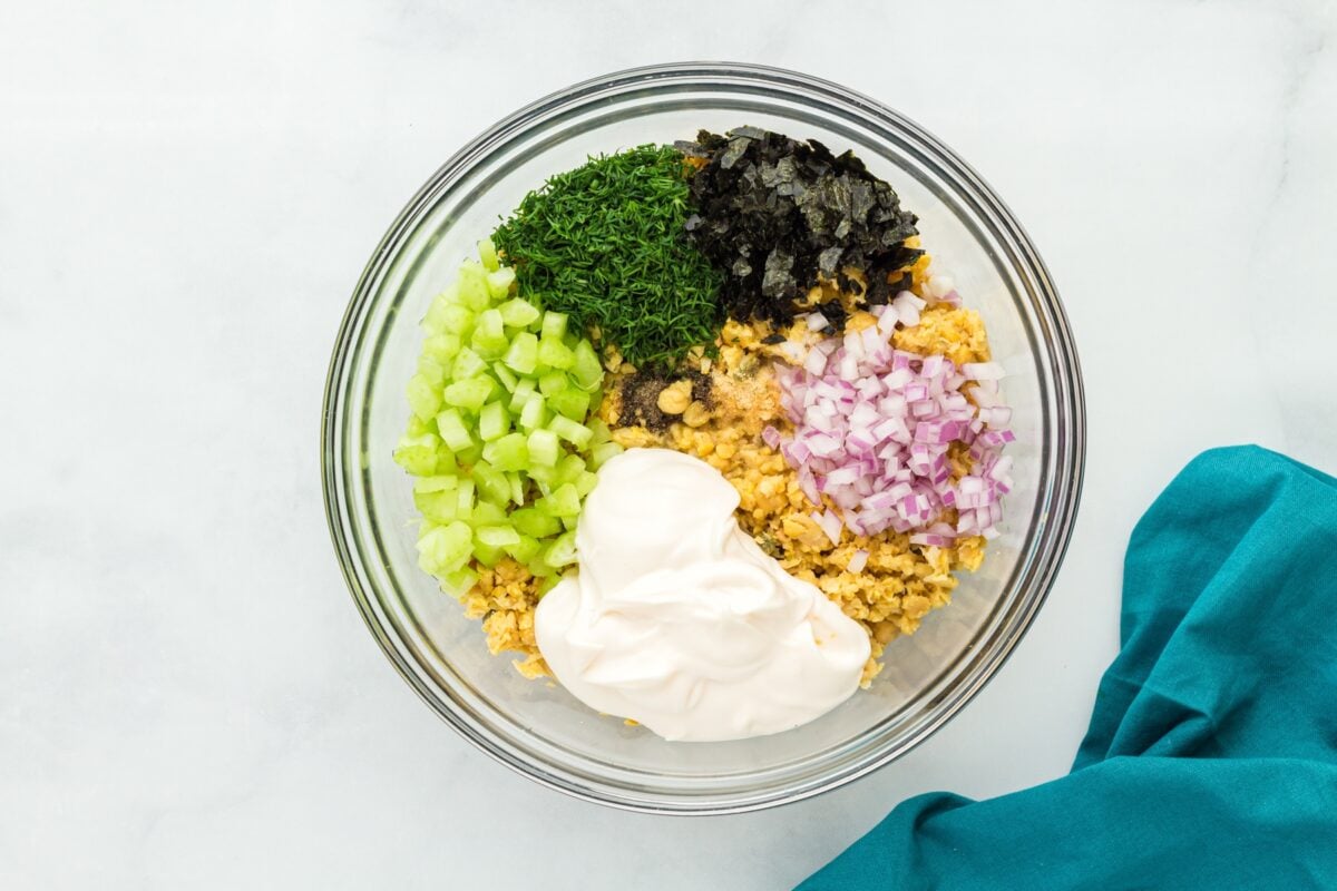 vegan tuna ingredients on top of mashed chickpeas in a glass bowl