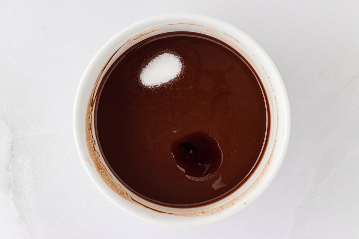 Melted chocolate in a white ramekin with salt and vanilla added.