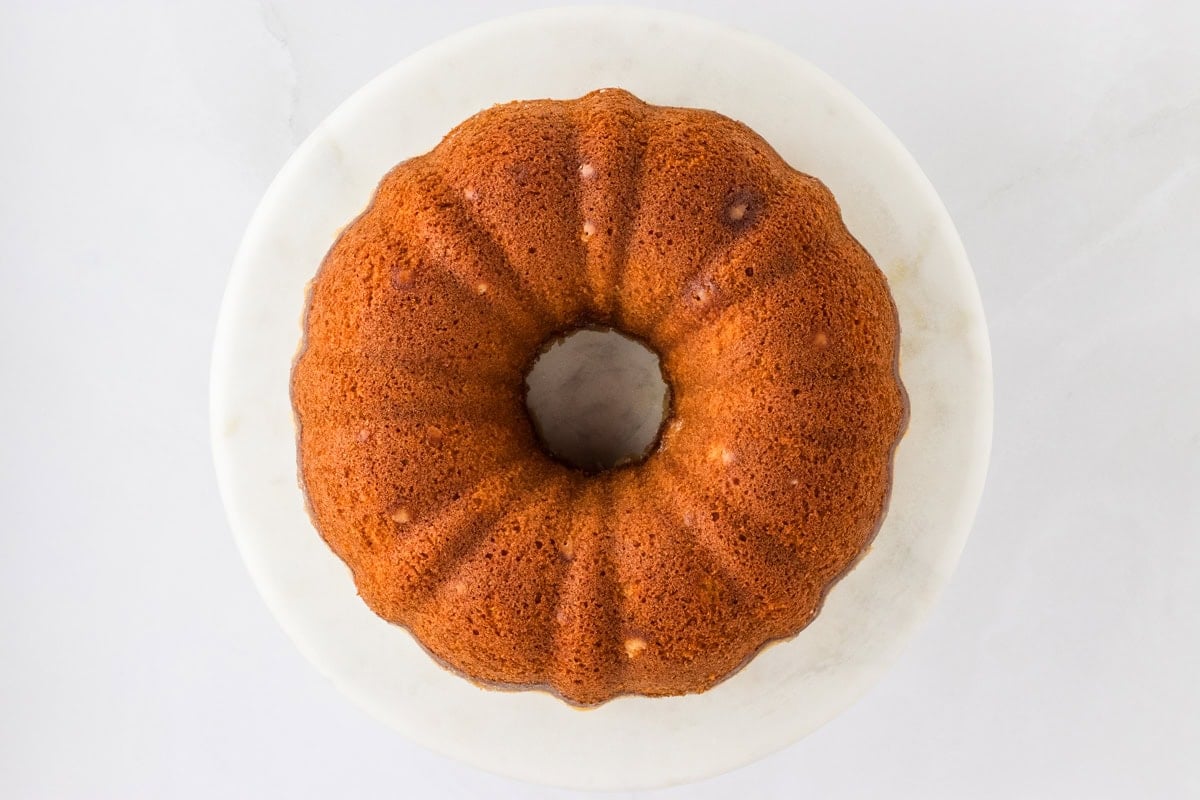 The finished Gluten-Free Kentucky Butter Pound Cake turned out onto a white marble platter, showcasing its golden-brown crust.