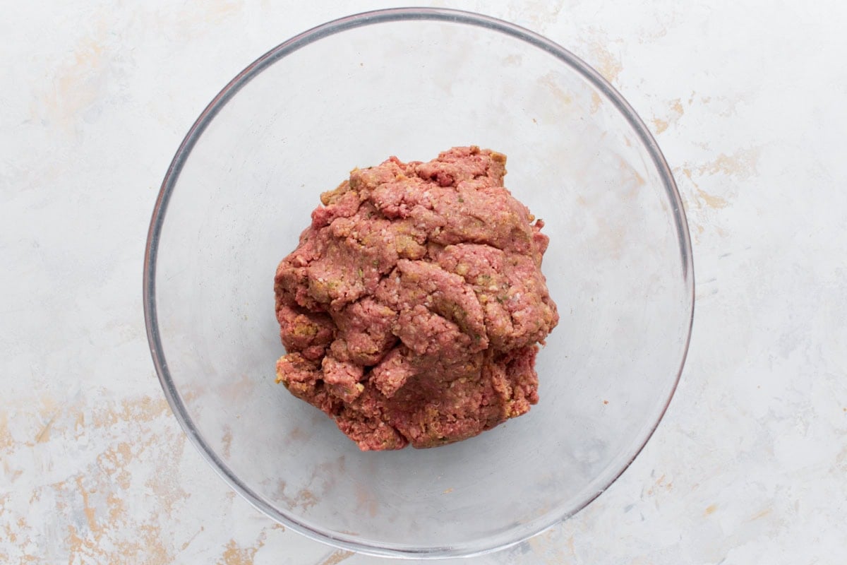 A mixing bowl with raw gluten-free meatloaf mixture, fully combined and ready for shaping.