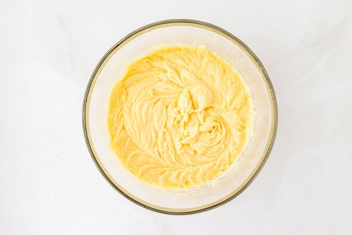 A glass mixing bowl containing the partially mixed batter for the Kentucky Butter Pound Cake, showing a smooth, creamy consistency.