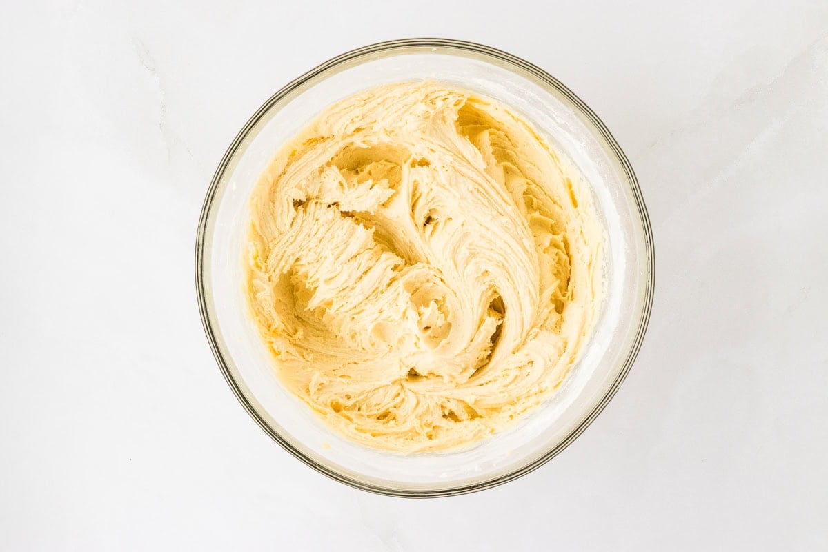 A glass mixing bowl with fully combined cake batter, ready to be transferred to a baking pan.