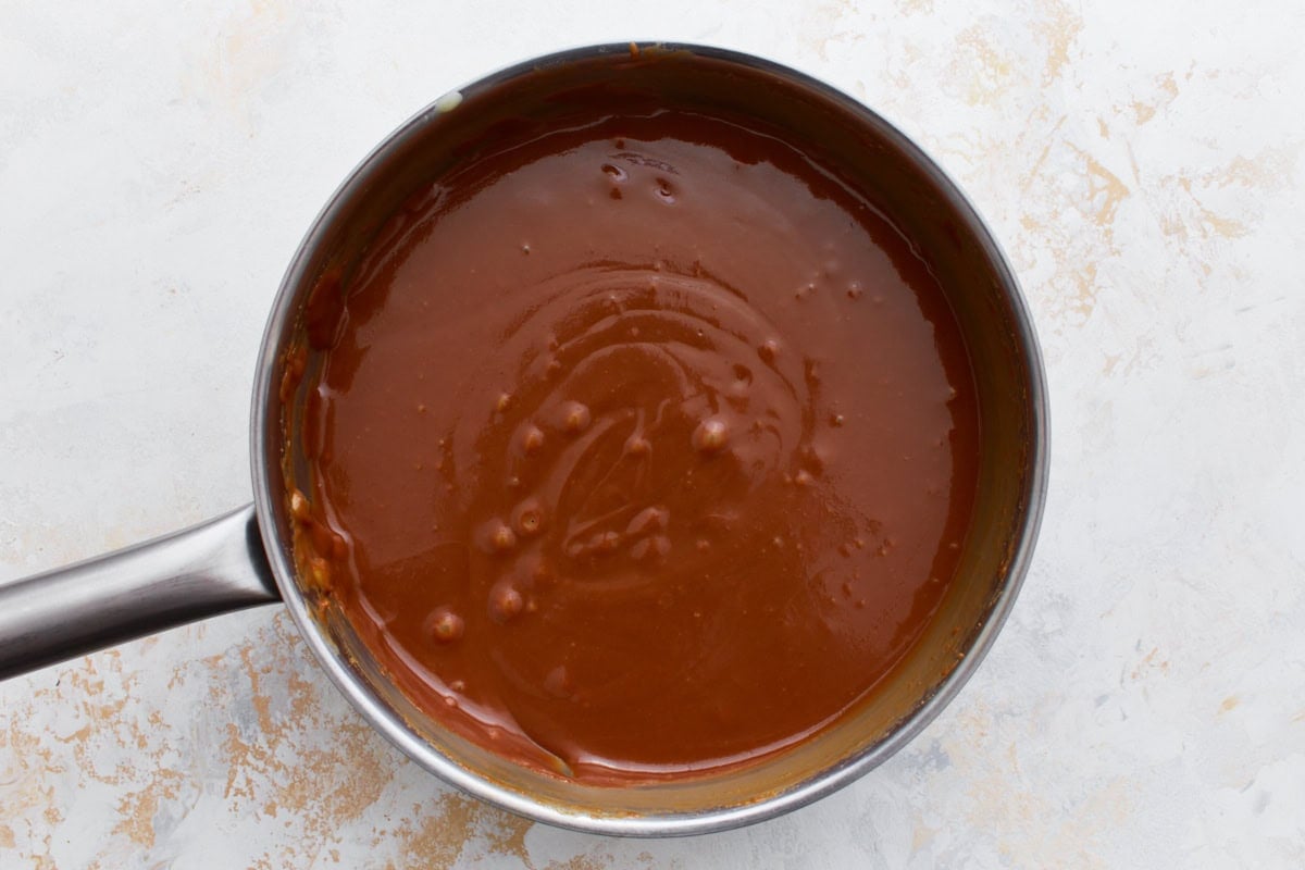 A saucepan filled with smooth, caramel-colored filling, freshly prepared and ready for layering.