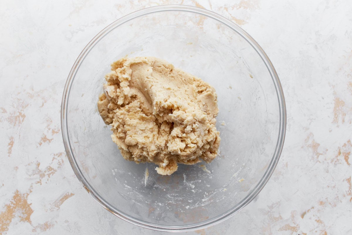 A glass bowl showing the partially mixed dough for gluten-free naan bread.