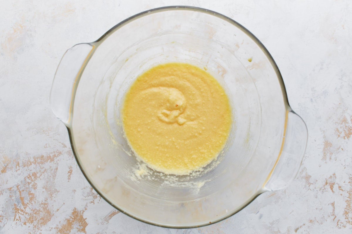 A glass bowl with a smooth, golden-yellow mixture of eggs, sugar, and butter, ready for the dry ingredients.