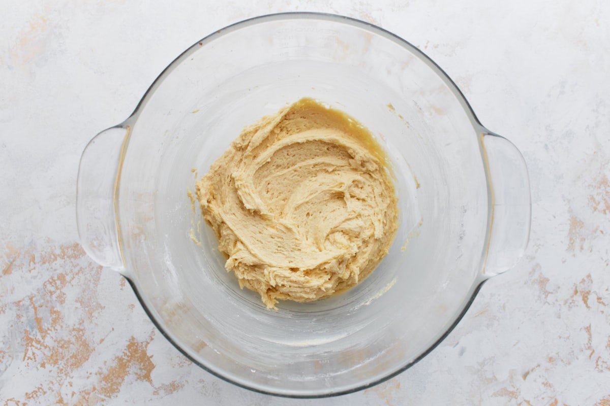 A thick gluten-free cake batter in a mixing bowl, just before adding the milk.