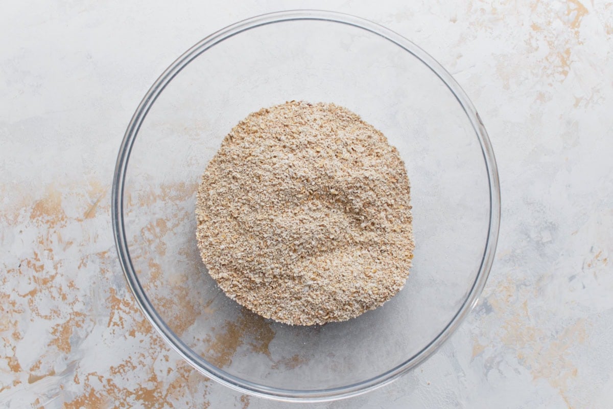 Coarse oat flour and other dry ingredients mixed together in a glass bowl