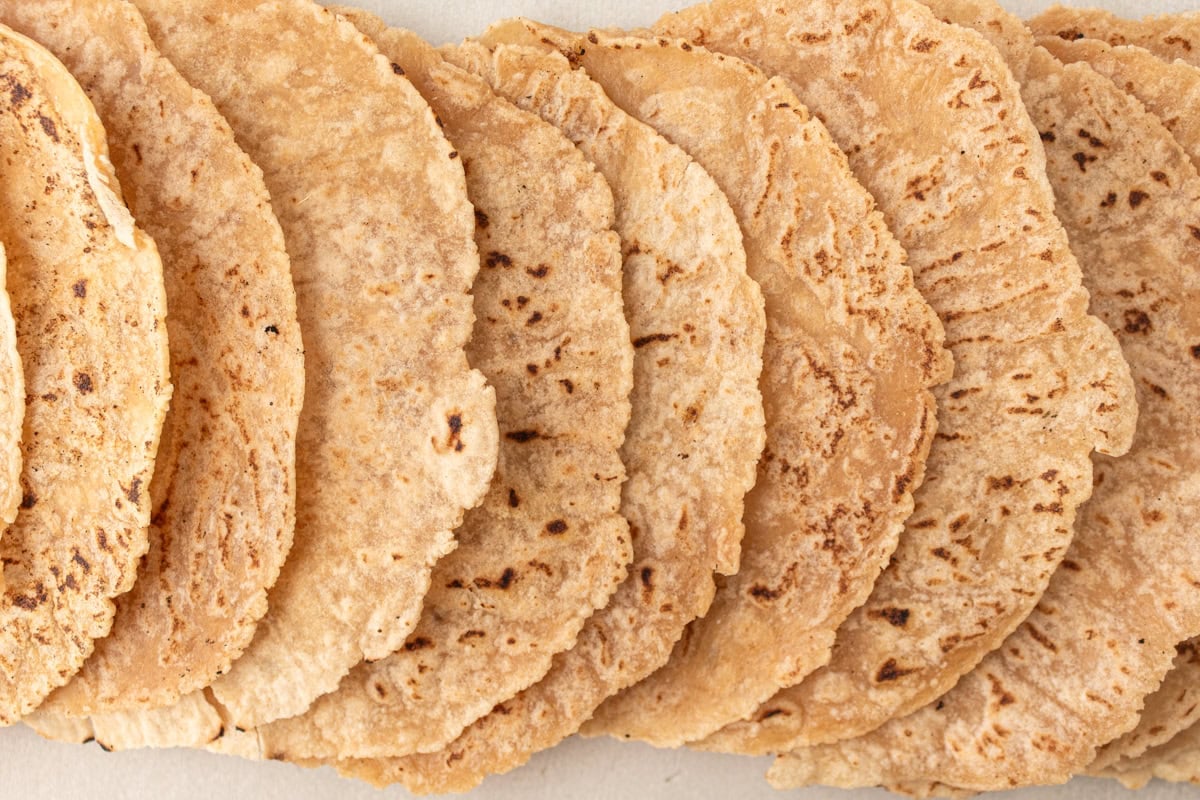 An overhead view of cassava tortillas arranged in a fanned-out pattern, highlighting their texture and golden brown spots.