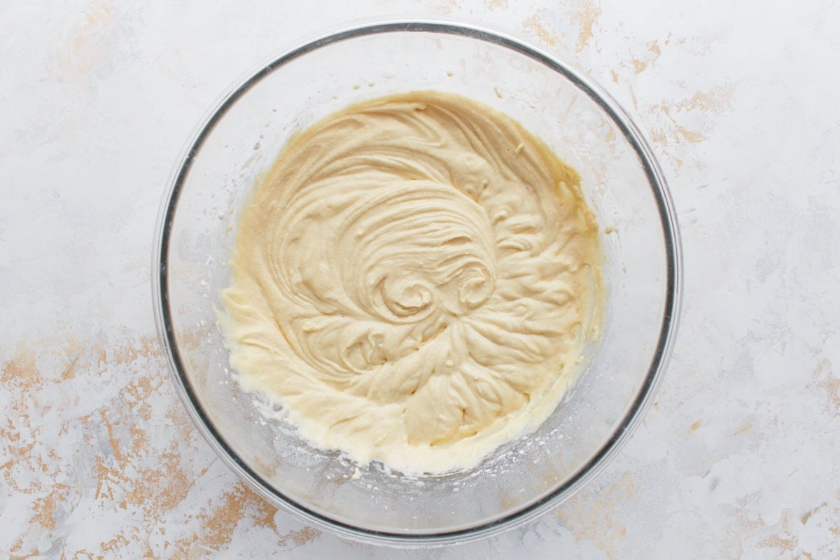 Final muffin batter in a glass bowl, smooth and ready for mix-ins like blueberries.