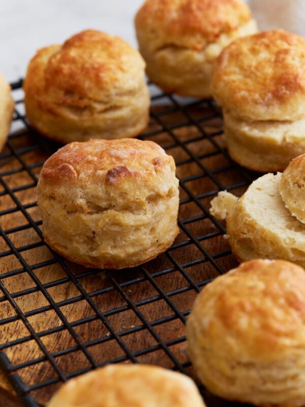 Freshly baked gluten-free buttermilk biscuits cooling on a wire rack, showing golden tops and flaky layers.
