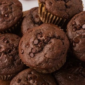 Close-up of a stack of gluten-free double chocolate muffins topped with melty chocolate chips.