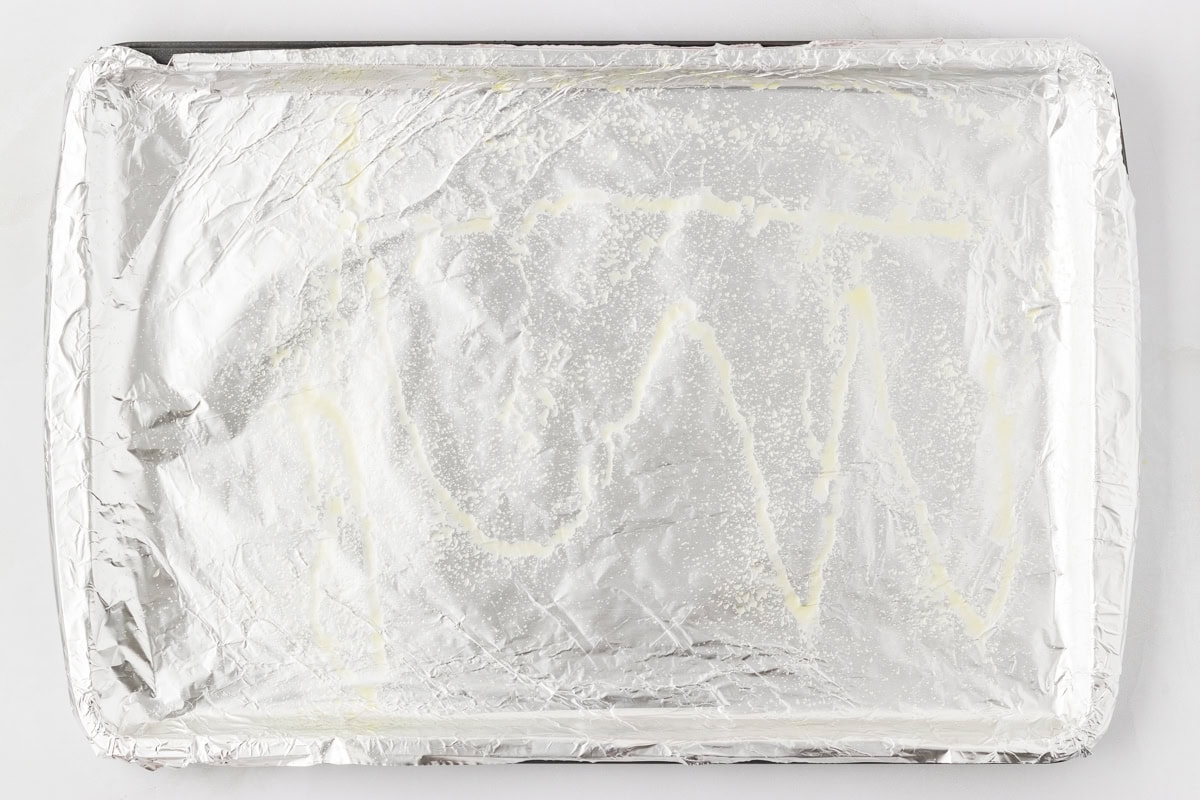 Foil-lined baking sheet lightly sprayed with oil, ready for baking meatballs.