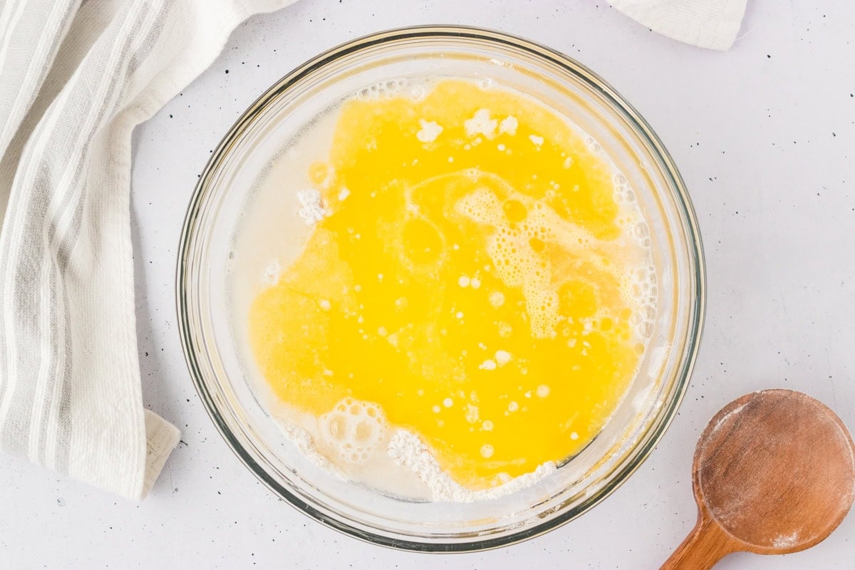 Bowl of wet ingredients including melted butter added to the flour for gluten-free breadstick dough.