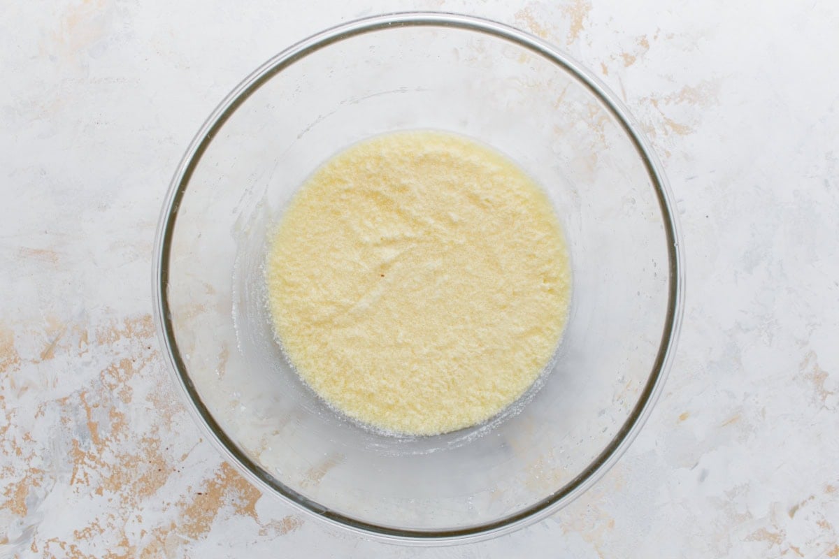 Bowl of wet ingredients just mixed together, pale yellow and smooth, ready to combine with the dry mix.