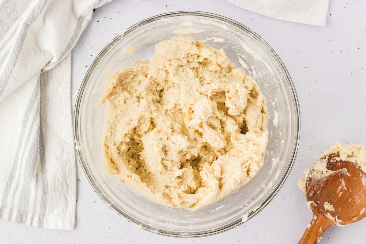 Gluten-free breadstick dough mixed into a thick, sticky batter in a glass bowl.