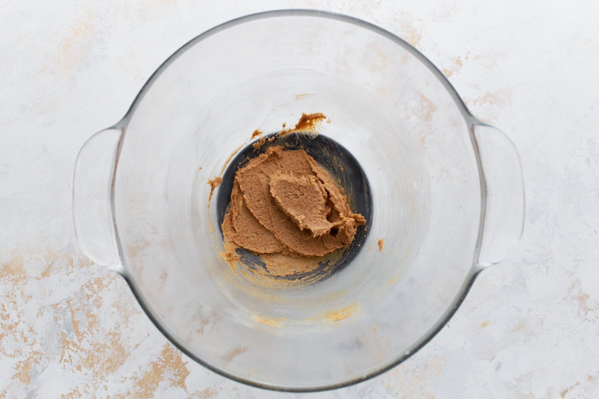Creamy cinnamon sugar topping mixture blended in a glass mixing bowl, ready to be added to the muffins.