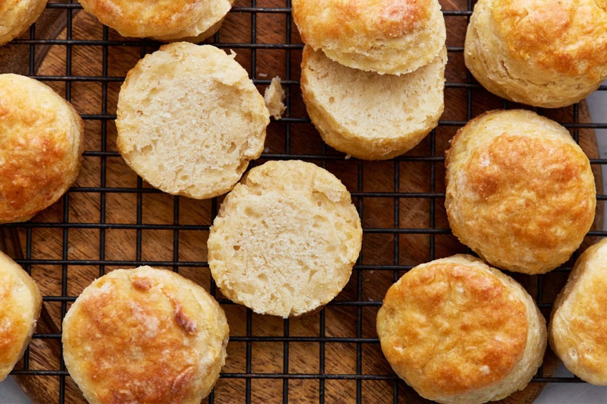 Overhead view of split gluten-free biscuits on a wire rack, revealing the tender, fluffy interior.
