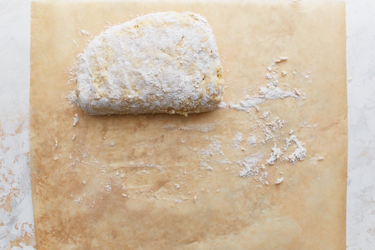 Dough folded a second time, with visible flour dusting on the parchment.