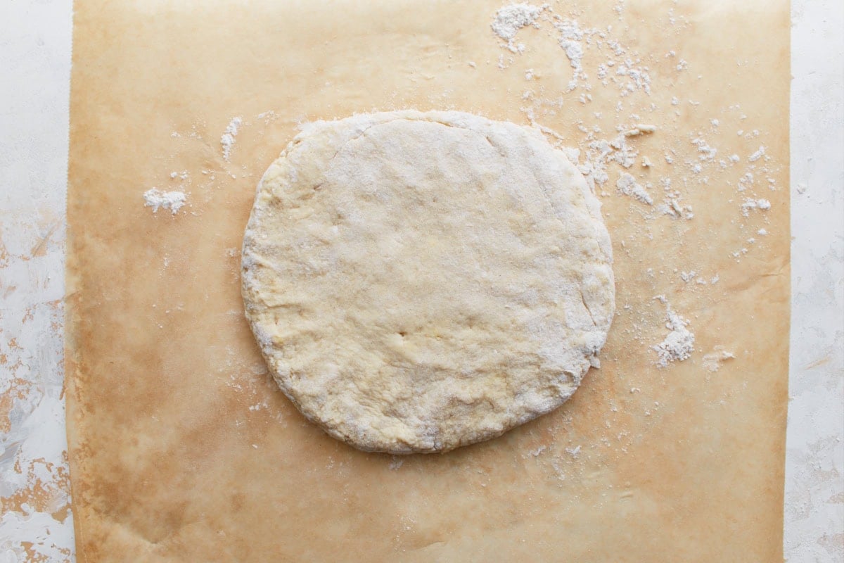 Final round of biscuit dough, ready for cutting, with a smooth, floured surface.